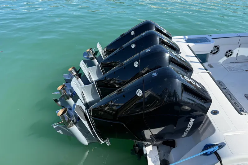Slide: The Image of Four powerful outboard motors on a 2020 Streamline 45 boat in clear water. - 42