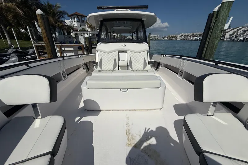 Slide: The Image of Luxurious 2020 Streamline 45 boat interior with white seating, docked by clear blue water. - 45
