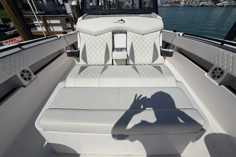 Slide: The Image of Luxury seating on a 2020 Streamline 45 boat, featuring diamond-stitched upholstery and coastal backdrop. - 46