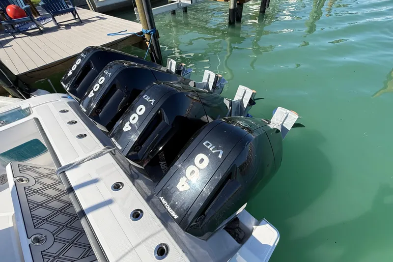 Slide: The Image of Four powerful outboard motors on a 2020 Streamline 45 boat docked in clear water. - 51