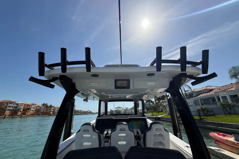 Slide: The Image of Streamline 45 boat interior, 2020 model, with rod holders, under sunny sky near waterfront homes. - 67