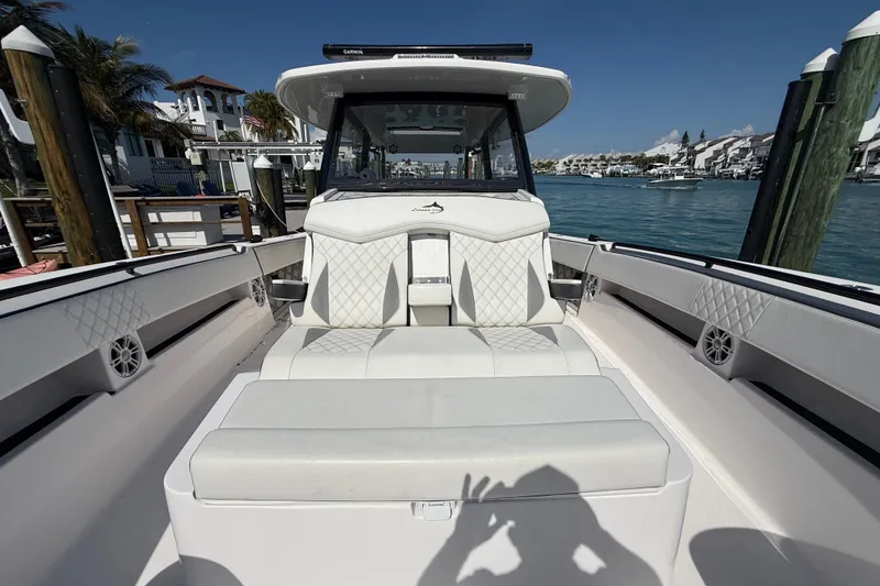 Slide: The Image of Streamline 45 boat interior with white seating, docked by waterfront homes, 2020 model. - 80