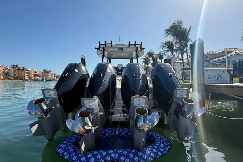 Slide: The Image of Four powerful outboard motors on a 2020 Streamline 45 boat docked by palm trees. - 9