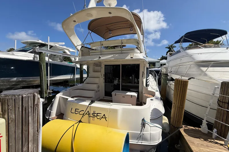 Slide: The Image of 1998 Sea Ray 400 Sedan Bridge yacht docked at marina under clear blue sky. - 1