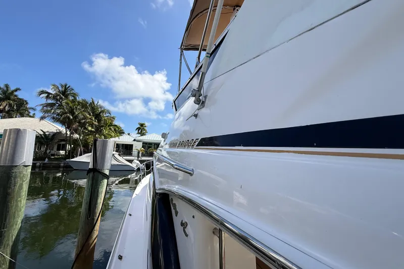 Slide: The Image of 1998 Sea Ray 400 Sedan Bridge yacht docked, sunny day, palm trees, blue sky. - 10