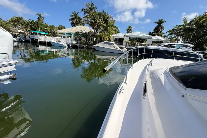 Slide: The Image of 1998 Sea Ray 400 Sedan Bridge docked in a scenic marina with palm trees. - 11