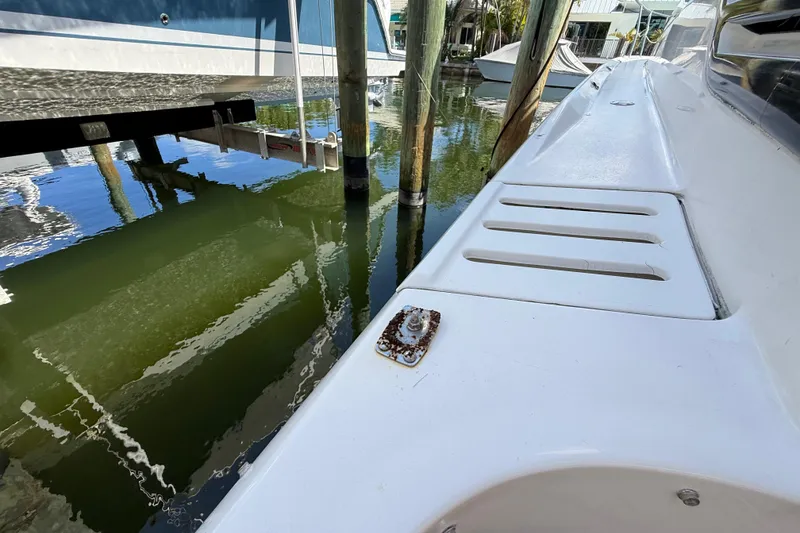 Slide: The Image of 1998 Sea Ray 400 Sedan Bridge docked, showing deck details and water reflection. - 12