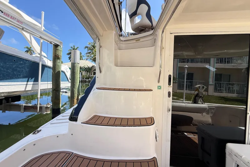 Slide: The Image of 1998 Sea Ray 400 Sedan Bridge yacht with teak steps and marina view. - 13