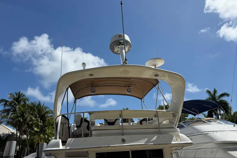 Slide: The Image of 1998 Sea Ray 400 Sedan Bridge yacht under clear blue sky with palm trees. - 17