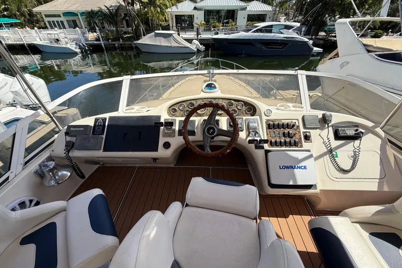 Slide: The Image of 1998 Sea Ray 400 Sedan Bridge helm with navigation equipment and wooden steering wheel. - 19