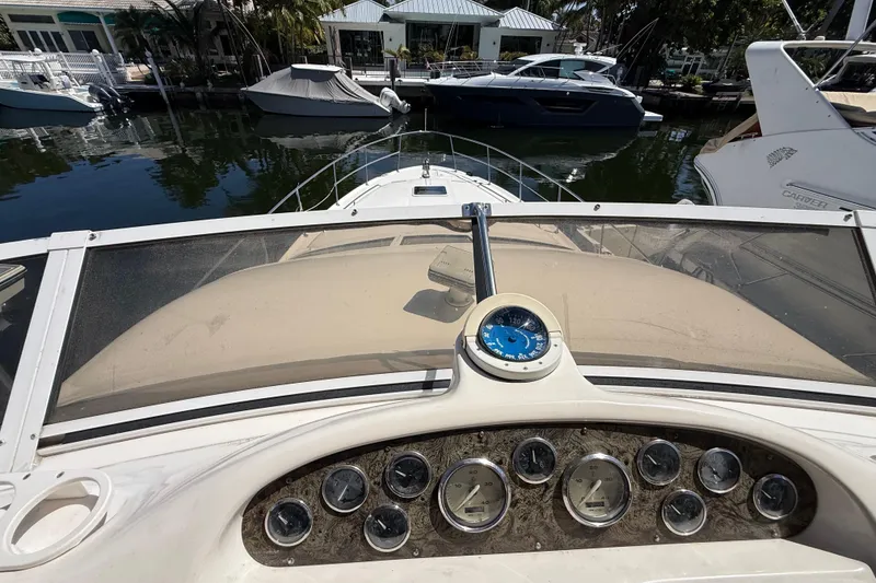 Slide: The Image of 1998 Sea Ray 400 Sedan Bridge dashboard with gauges, marina view in background. - 20