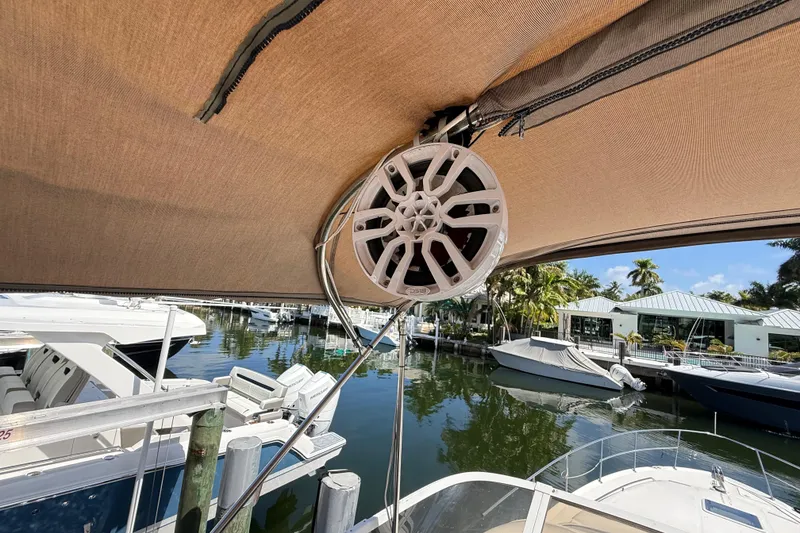 Slide: The Image of 1998 Sea Ray 400 Sedan Bridge with speaker under canopy at marina. - 25