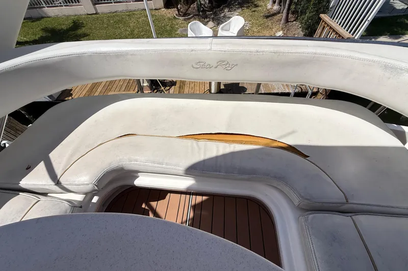 Slide: The Image of 1998 Sea Ray 400 Sedan Bridge with worn white seating and visible tear. - 27