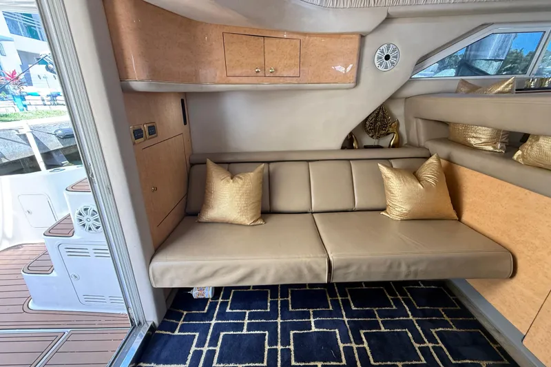 Slide: The Image of Luxurious interior of 1998 Sea Ray 400 Sedan Bridge with beige sofa and gold pillows. - 32
