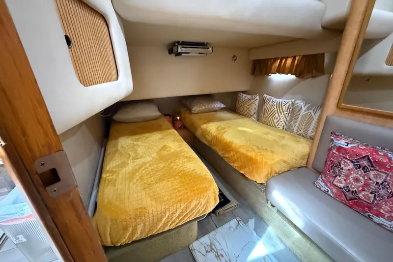 Slide: The Image of 1998 Sea Ray 400 Sedan Bridge cabin with twin beds and decorative pillows. - 33
