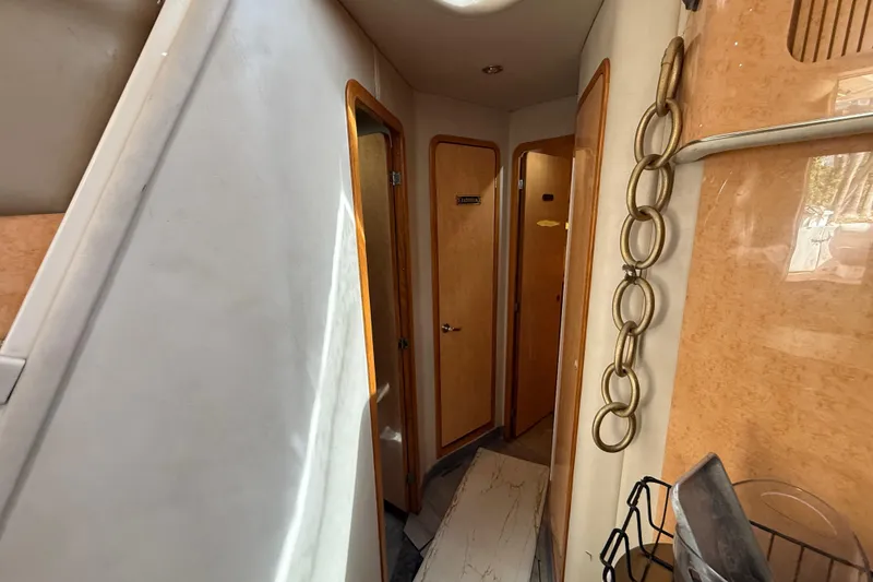 Slide: The Image of Interior hallway of 1998 Sea Ray 400 Sedan Bridge yacht with wooden doors and decor. - 34