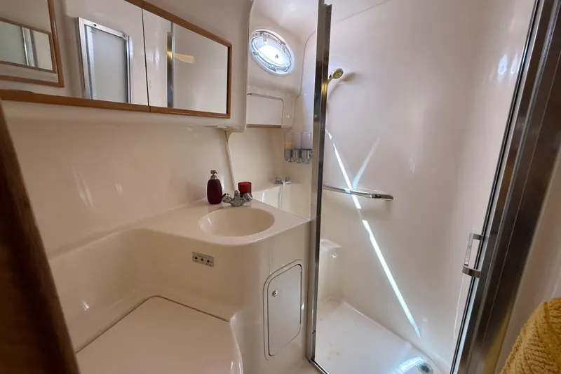 Slide: The Image of 1998 Sea Ray 400 Sedan Bridge bathroom with sink, mirror, and shower. - 40
