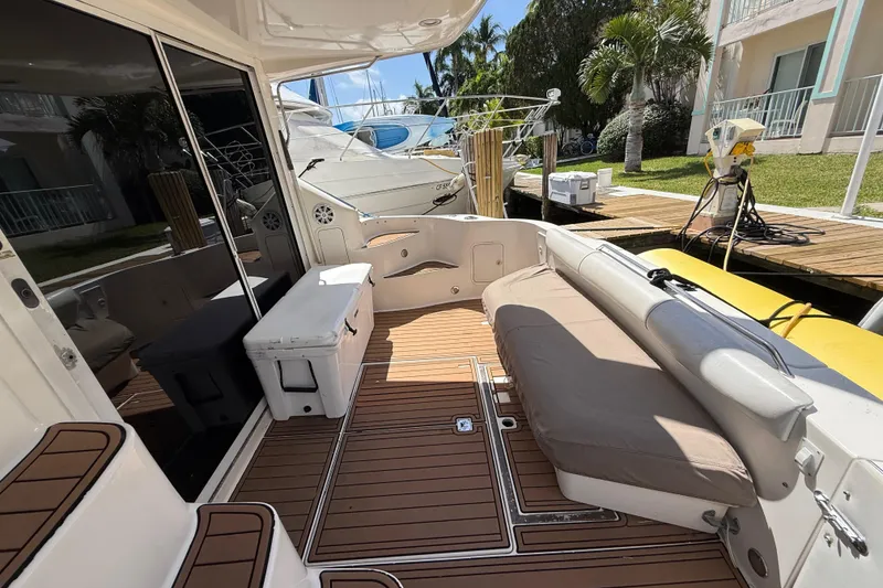 Slide: The Image of 1998 Sea Ray 400 Sedan Bridge yacht with spacious deck and seating area at marina. - 42