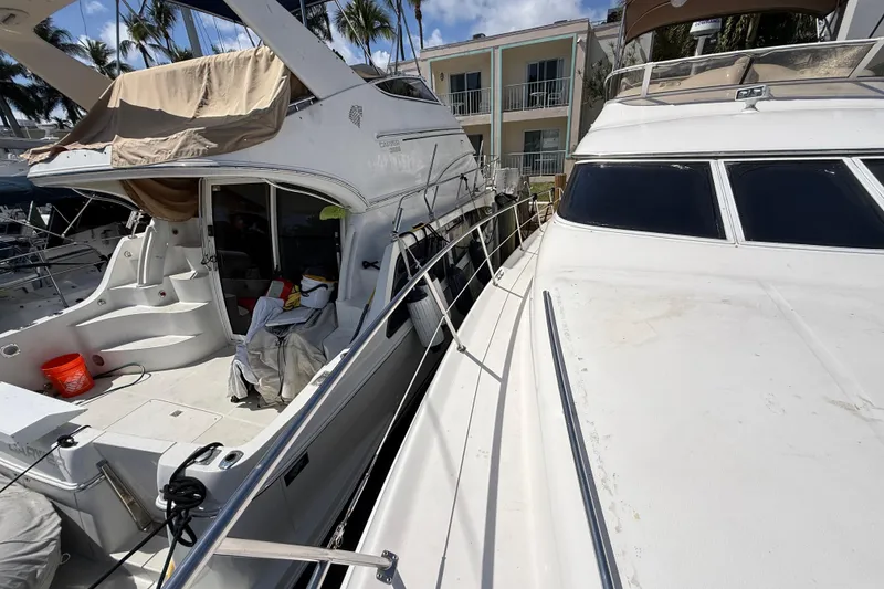 Slide: The Image of 1998 Sea Ray 400 Sedan Bridge yacht docked alongside another boat. - 5