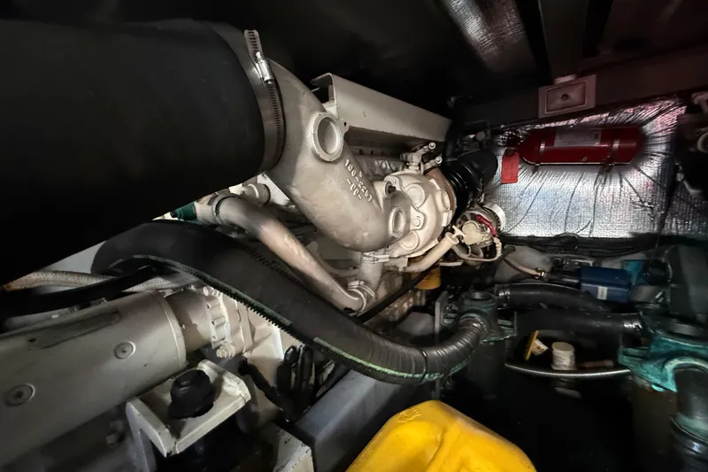 Slide: The Image of Engine room of a 1998 Sea Ray 400 Sedan Bridge with visible components and hoses. - 50