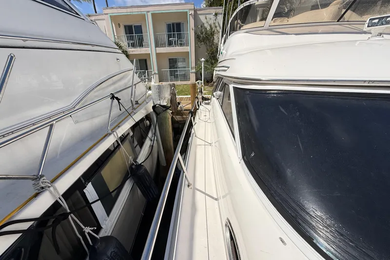 Slide: The Image of 1998 Sea Ray 400 Sedan Bridge yacht docked beside another boat. - 6