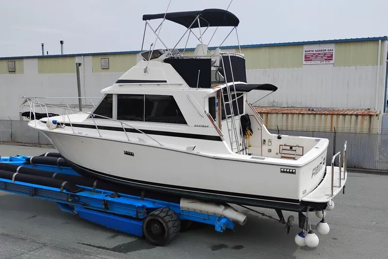 Slide: The Image of 1978 Bertram 33 Convertible boat on trailer, white exterior, dockside view. - 1