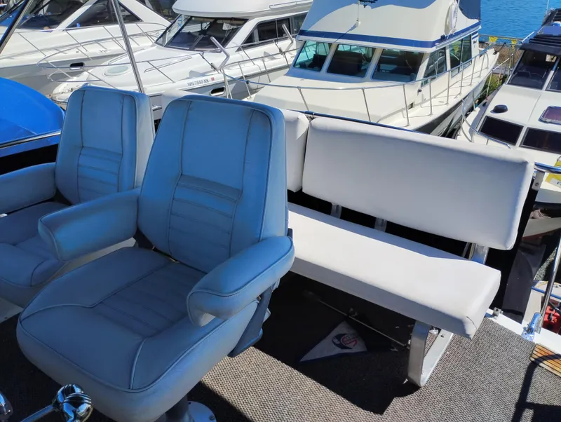 Slide: The Image of 1978 Bertram 33 Convertible boat interior with blue captain chairs and white bench seating. - 17