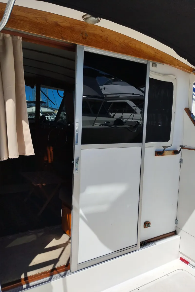Slide: The Image of 1978 Bertram 33 Convertible boat interior with sliding door and curtain. - 18