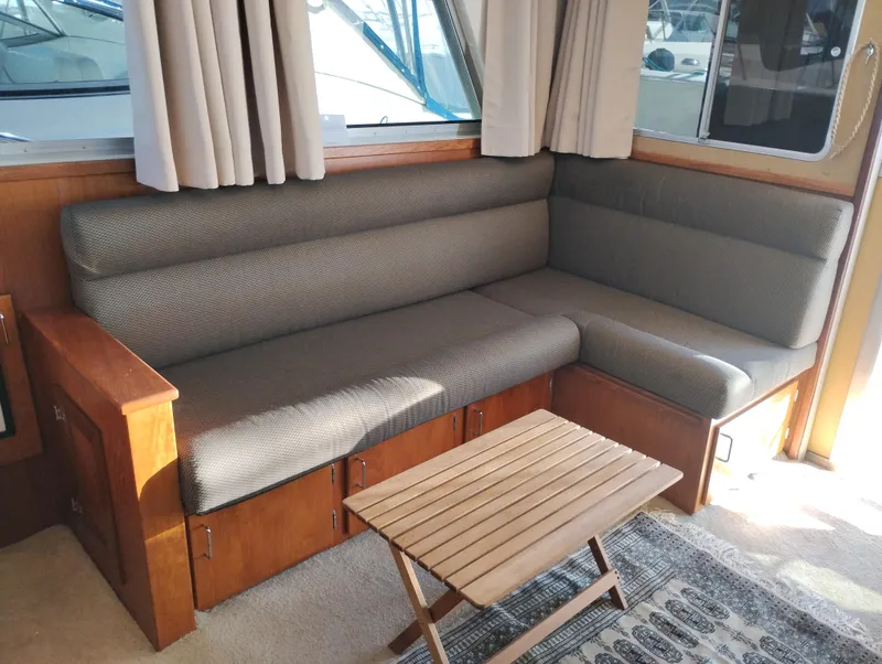 Slide: The Image of Interior of a 1978 Bertram 33 Convertible with a cozy seating area and wooden table. - 20