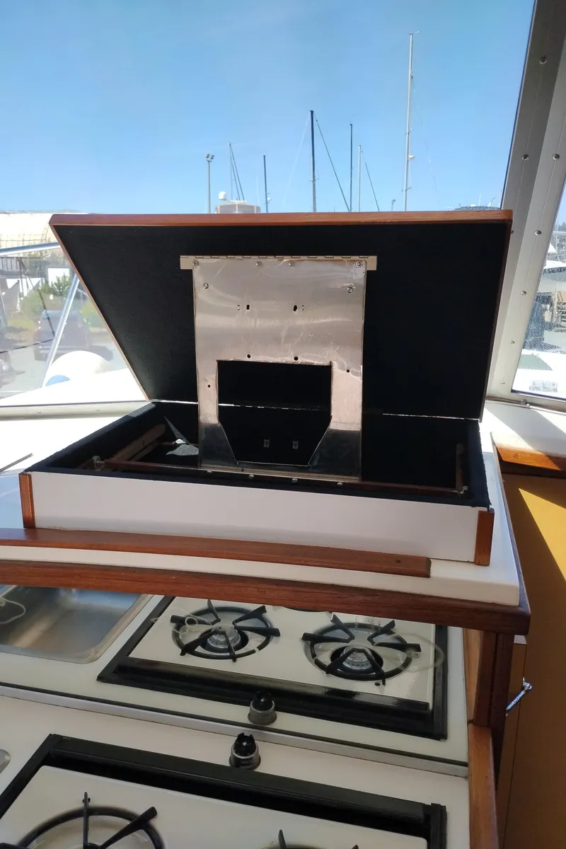 Slide: The Image of 1978 Bertram 33 Convertible yacht kitchen with stove and open storage compartment. - 27