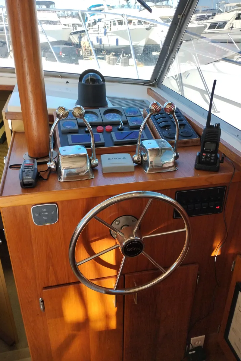 Slide: The Image of 1978 Bertram 33 Convertible helm with steering wheel, throttle controls, and communication devices. - 29