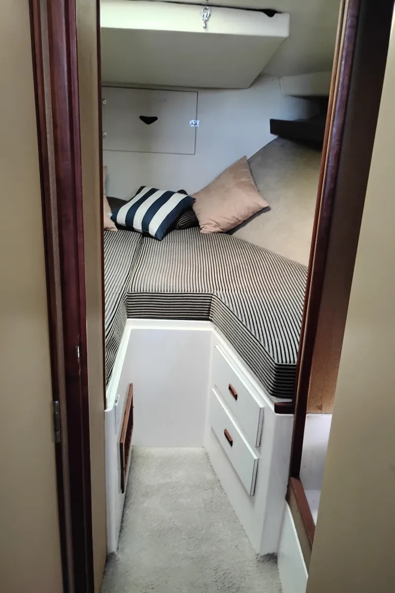 Slide: The Image of 1978 Bertram 33 Convertible cabin interior with striped bedding and pillows. - 39