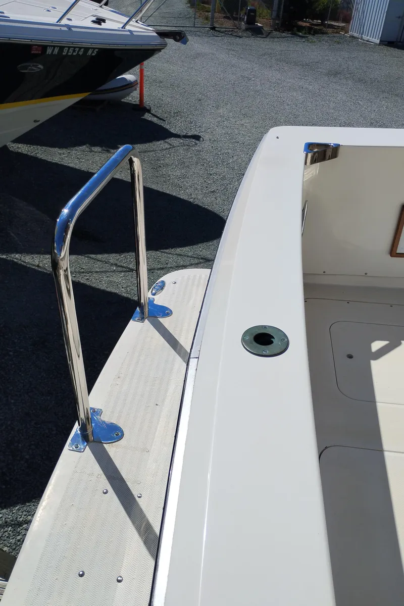 The Image of 1978 Bertram 33 Convertible boat deck with stainless steel railing and clean white surface. - 4