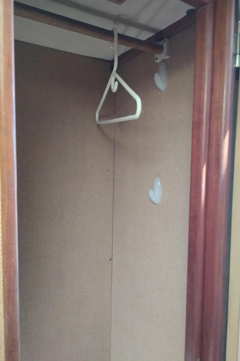 Slide: The Image of Empty closet with wooden frame and hanger inside a 1978 Bertram 33 Convertible boat. - 46