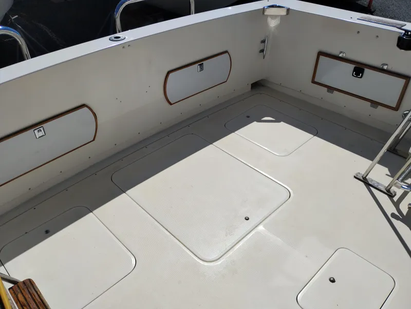 Slide: The Image of 1978 Bertram 33 Convertible boat deck with storage compartments and clean white surface. - 5