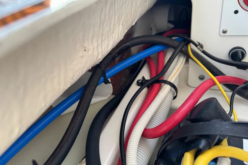 Slide: The Image of Colorful wiring inside a 2022 Robalo 266 Cayman boat, showcasing electrical components. - 106