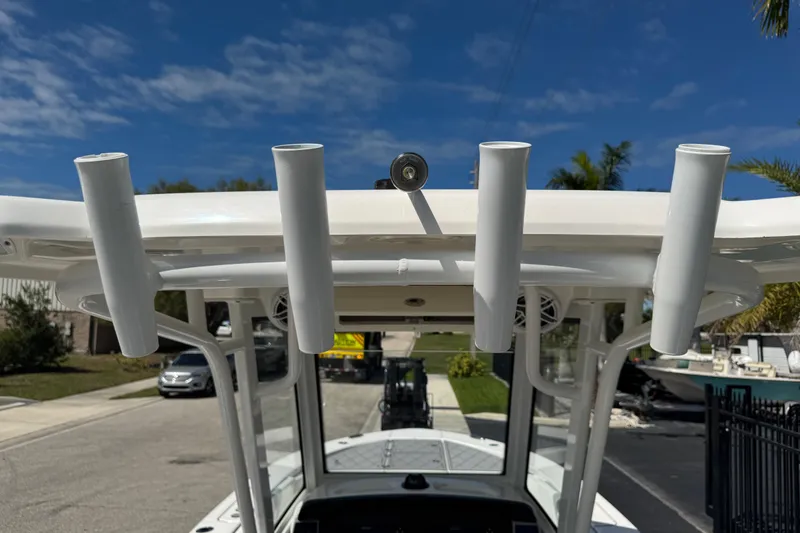 Slide: The Image of 2022 Robalo 266 Cayman boat with rod holders under a clear blue sky. - 111