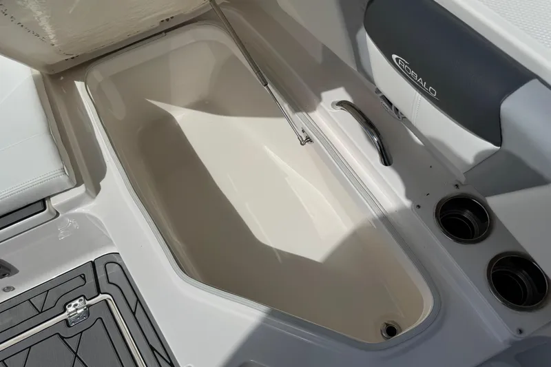 Slide: The Image of 2022 Robalo 266 Cayman boat storage compartment with open hatch and sleek design. - 120