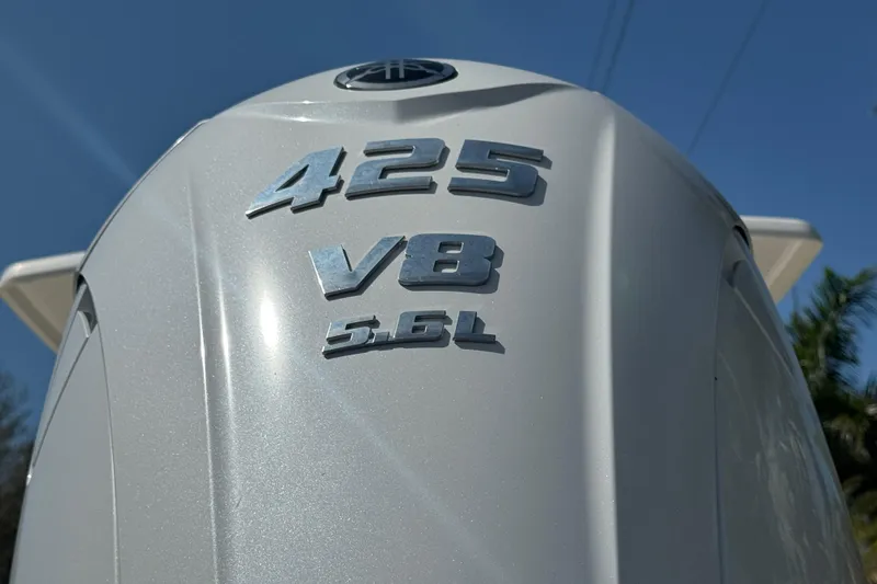 Slide: The Image of 2022 Robalo 266 Cayman boat on trailer, parked near palm trees. - 2