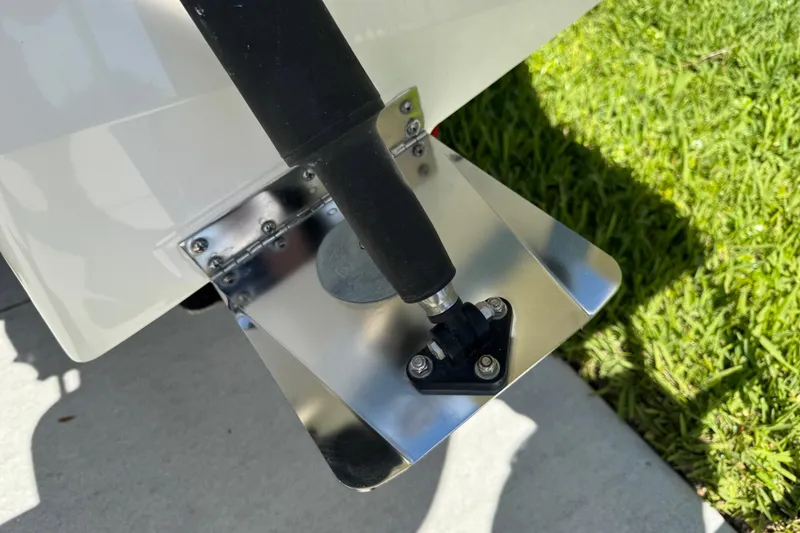 Slide: The Image of Trim tab of 2022 Robalo 266 Cayman boat on grass background. - 34