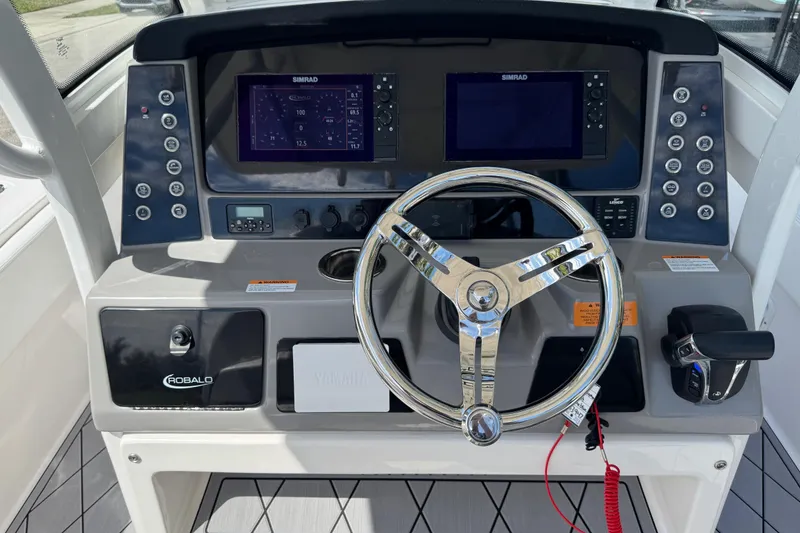 Slide: The Image of 2022 Robalo 266 Cayman boat dashboard with steering wheel and electronic controls. - 40