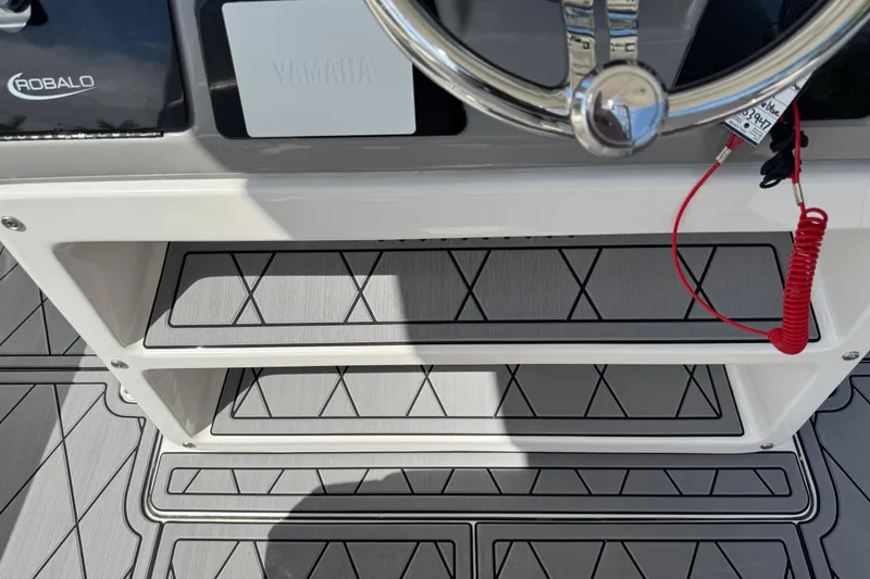 Slide: The Image of 2022 Robalo 266 Cayman boat helm with steering wheel and red safety cord. - 41