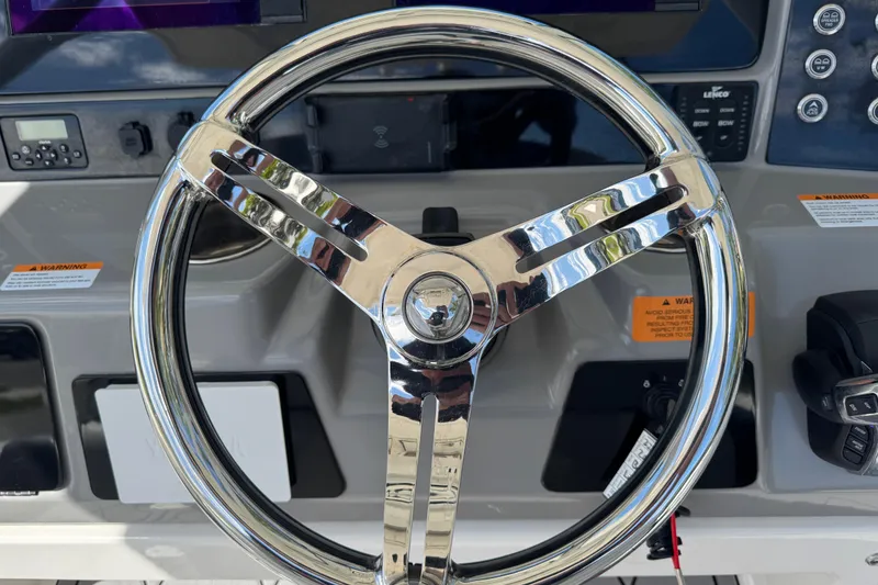 Slide: The Image of Steering wheel of 2022 Robalo 266 Cayman boat, featuring modern dashboard controls. - 42
