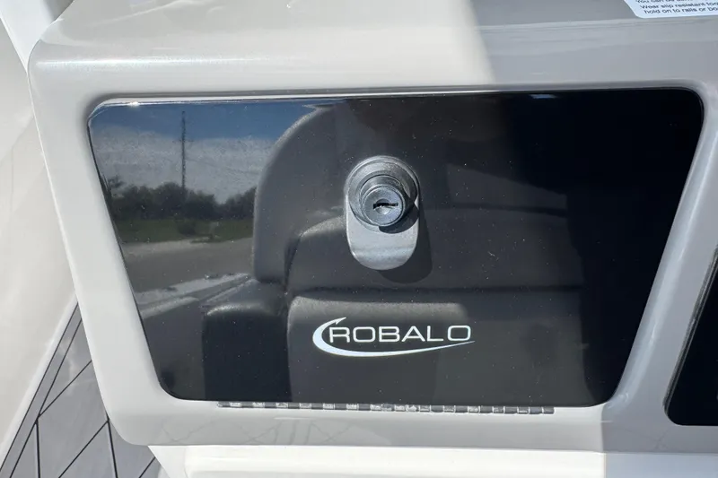 Slide: The Image of Robalo 266 Cayman 2022 boat compartment with lock and logo. - 49
