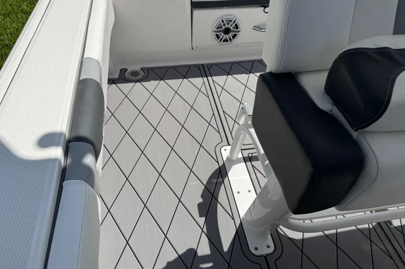 Slide: The Image of 2022 Robalo 266 Cayman boat interior with cushioned seating and diamond-patterned flooring. - 52