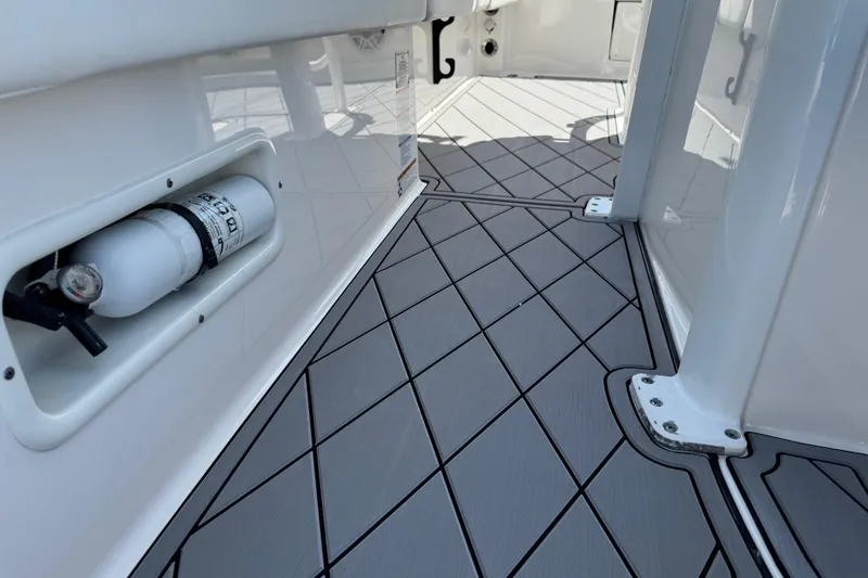 Slide: The Image of 2022 Robalo 266 Cayman boat interior with non-slip flooring and fire extinguisher. - 55