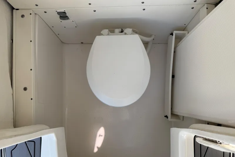 Slide: The Image of 2022 Robalo 266 Cayman boat interior with compact marine toilet. - 58