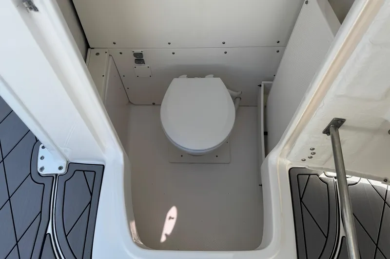 Slide: The Image of 2022 Robalo 266 Cayman boat interior with compact marine toilet. - 59