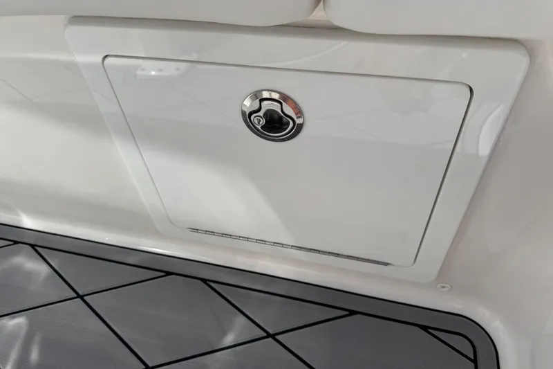 Slide: The Image of Storage compartment on 2022 Robalo 266 Cayman boat, featuring a secure latch. - 63