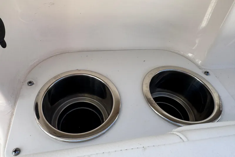 Slide: The Image of Cup holders on a 2022 Robalo 266 Cayman boat, featuring stainless steel rims. - 66
